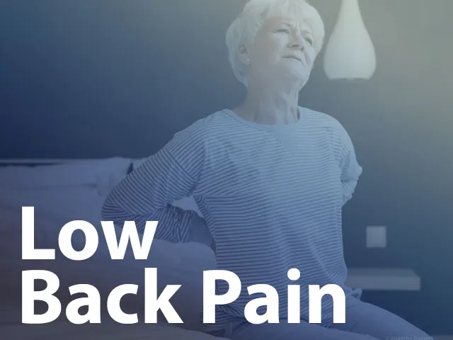 Lady experiencing low back pain getting out of bed.